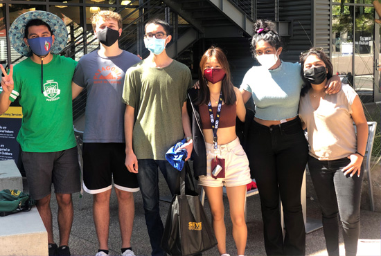 masked student orientation leaders standing outside of the Seventh College Market